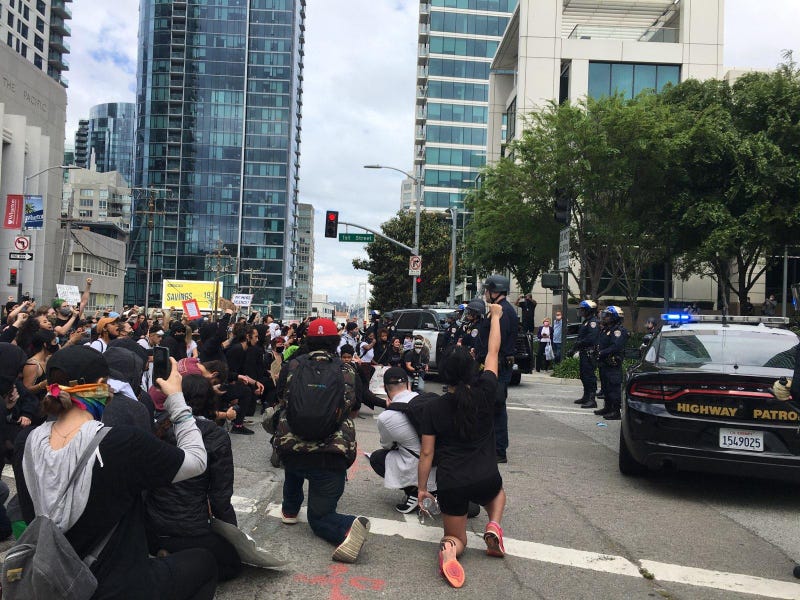 Protesters kneel in front of police at a San Francisco rally.