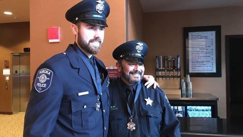 Two Aurora police officers have returned to full duty nearly nine months after being wounded in a mass shooting at the Henry Pratt Company.