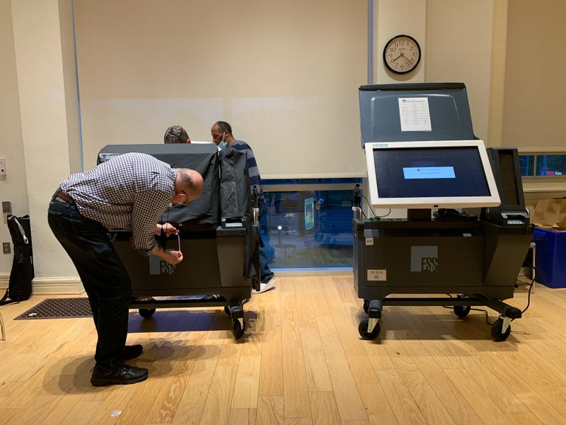 An election worker in Philadelphia, Pennsylvania examines an ExpressVoteXL voting machine during the 2022 primary.