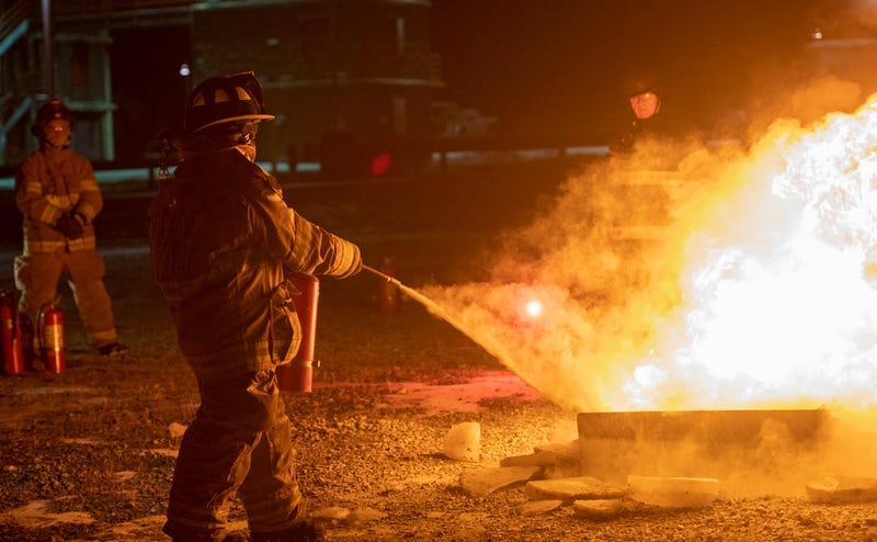 A firefighter puts out a fire during a training class.