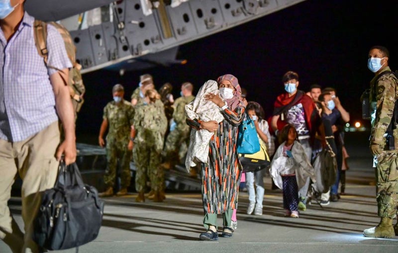 Afghan evacuees disembark a U.S. Air Force plane. 