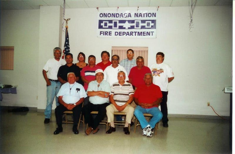 The Onondaga Nation Volunteer Department celebrates its first anniversary in 1998. Back row: Sheldon Gibson, Sonny Shen, Steph Bush, Alson Gibson, Anthony Honyoust, Ron Shen, Nick Gibson, Erwin Gibson, Larry Burk; front row: Nel Jones, Irv Powless Jr, Sam Babcock, Joe Logan