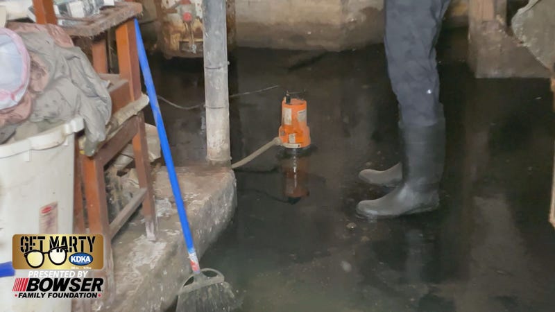 Marty Griffin stands in raw sewage in the basement of Tonya Todd's home in Homewood.