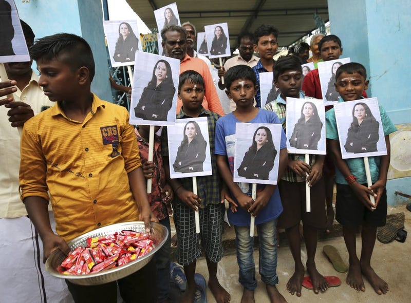 A child holds a tray of chocolates as others hold portraits of U.S. Vice President-elect Kamala Harris after participating in special prayers ahead of her inauguration, at a Hindu temple in Thulasendrapuram, the hometown of Harris' maternal grandfather, south of Chennai, Tamil Nadu state, India, Wednesday, Jan. 20, 2021. A tiny, lush-green Indian village surrounded by rice paddy fields was beaming with joy Wednesday hours before its descendant, Kamala Harris, takes her oath of office and becomes the U.S. vice president.