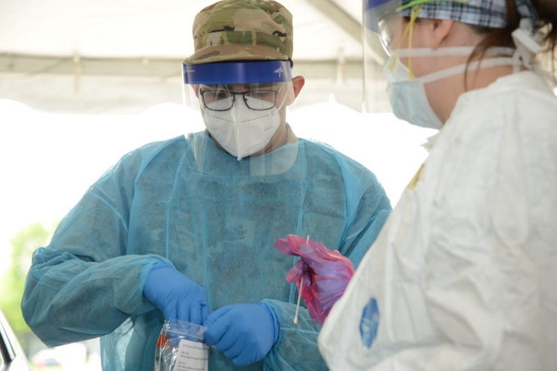 U.S. Air National Guard Senior Airman Manuel Zertuche 185th Air Refueling Wing medical technician works with medical staff in order to administer a COVID-19 test at the Sioux Center, Iowa “TestIowa” test site on May 27, 2020. 