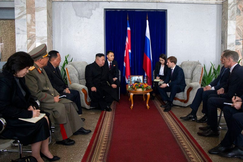 North Korea's leader Kim Jong Un, background, centre left, talks with Russian Minister for the development of the Russian Far East Alexander Kozlov