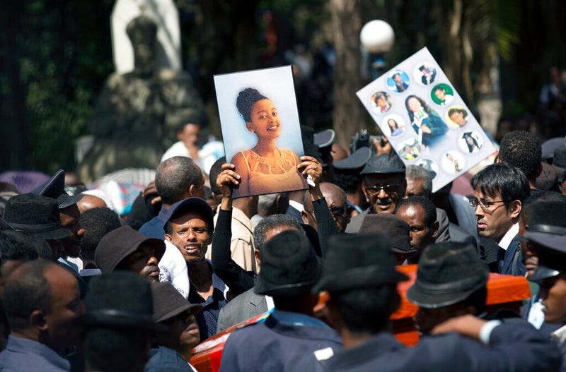 Relatives hold photographs of the victims at a mass funeral at the Holy Trinity Cathedral in Addis Ababa, Ethiopia Sunday, March 17, 2019.