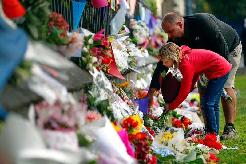 Mourners lay flowers on a wall at the Botanical Gardens in Christchurch, New Zealand, Saturday, March 16, 2019.