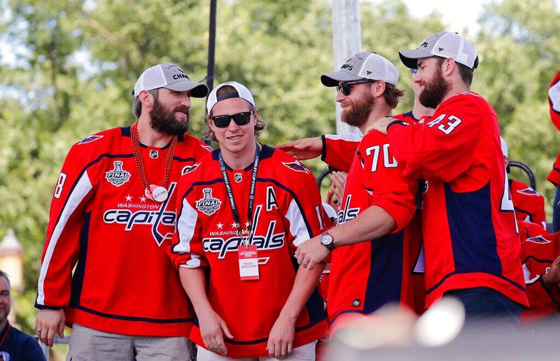 Washington Capitals' Alex Ovechkin (8), of Russia; Nicklas Backstrom (19), of Sweden; Braden Holtby (70); and Tom Wilson (43) greet each other on stage during the Stanley Cup victory celebration on the National Mall in Washington.