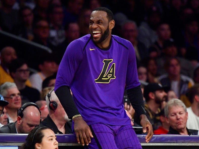 Los Angeles Lakers forward LeBron James laughs as he waits to check in to the team's NBA basketball game against the Charlotte Hornets during the second half Friday, March 29, 2019, in Los Angeles. The Lakers won 129-115.