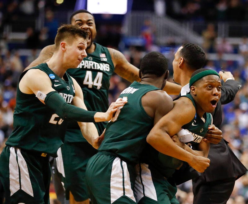 Michigan State guard Cassius Winston, right, celebrates with teammates Matt McQuaid (20), Nick Ward (44) and Gabe Brown (13) after defeating Duke in an NCAA men's East Regional final college basketball game in Washington, Sunday, March 31, 2019.