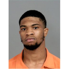 Black man in 20s frowning with short black hair, black beard