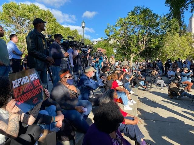 A few hundred people gather for a vigil at Lake Merritt on Tuesday following the Juneteenth mass shooting.