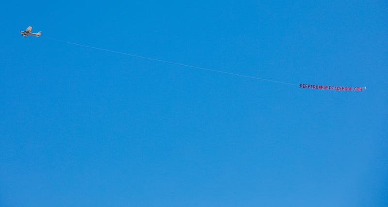 A prop plane flies a banner reading "KEEPTRUMPOFFFACEBOOK.COM" overhead at Facebook's Menlo Park headquarters in California on June 15.