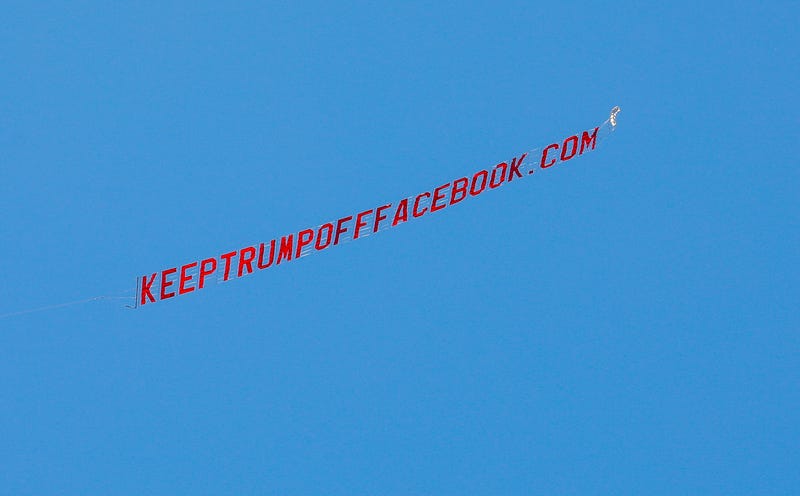 A prop plane flies a banner reading "KEEPTRUMPOFFFACEBOOK.COM" overhead at Facebook's Menlo Park headquarters in California on June 15.