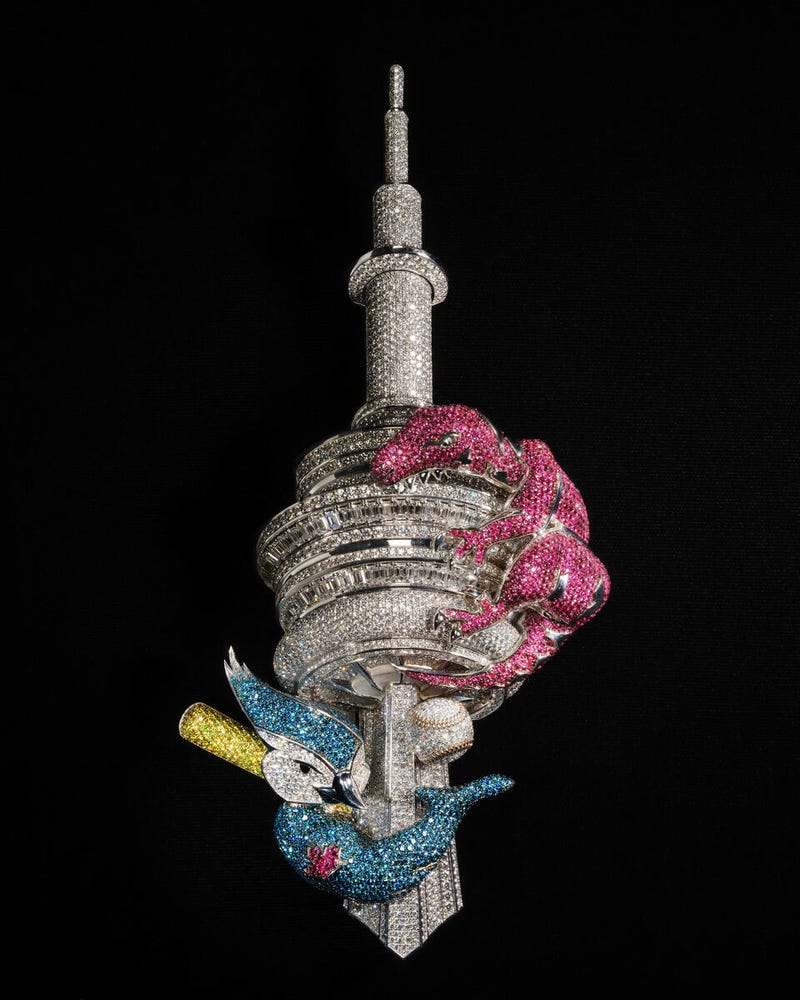This pendant—designed by Alex Moss in 2023 to celebrate Drake’s hometown of Toronto—boasts multicolored diamonds and rubies on 18-karat gold and features the mascots for the Toronto Raptors and the Toronto Blue Jays wrapped around Toronto’s CN Tower.