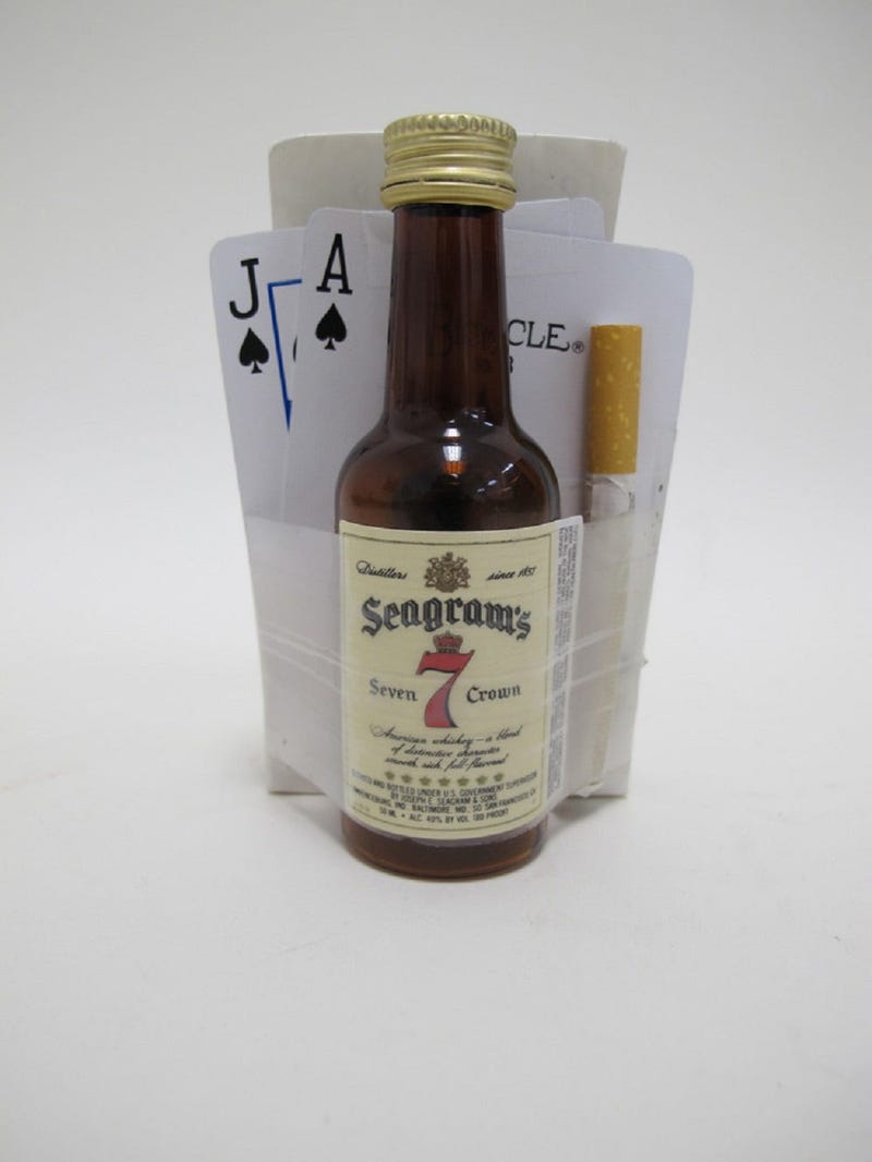 Deck of playing cards, mini bottle of whiskey, and cigarette with note left at the Vietnam Veterans Memorial in Washington, DC.