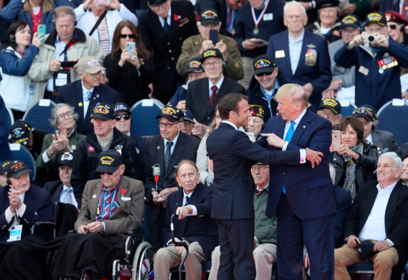 U.S. President Donald Trump, right, and French President Emmanuel Macron speak with each other during a ceremony to mark the 75th anniversary of D-Day at the Normandy American Cemetery in Colleville-sur-Mer, Normandy, France