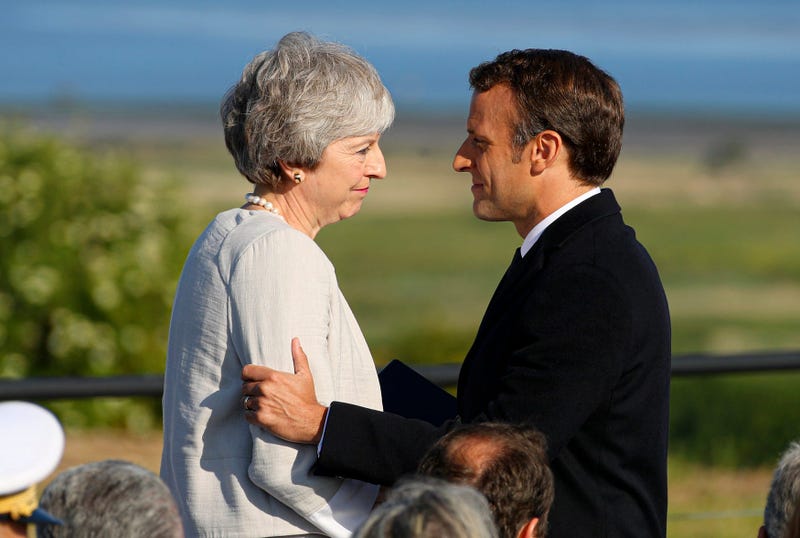 French President Emmanuel Macron greets British Prime Minister Theresa May during a Franco-British ceremony to mark the 75th anniversary of D-Day landings and laying the first stone of a British memorial at Ver-Sur-Mer, Normandy, France.