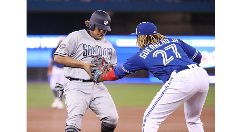 Josh Naylor #22 of the San Diego Padres is tagge dout as he tries to advance to third base by Vladimir Guerrero Jr. #27 of the Toronto Blue Jays in the first inning during MLB game action at Rogers Centre on May 25, 2019 in Toronto, Canada. (Photo by Tom 