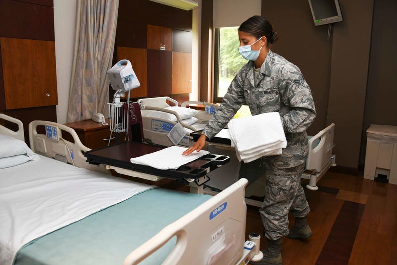 Air Force Airman 1st Class Maria Bandstra, a medical technician assigned to the 316th Aerospace Medicine Squadron, places a towel in a patient room at the Aeromedical Staging Facility at Joint Base Andrews, Md.