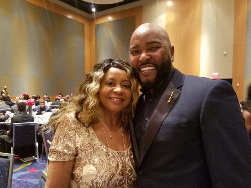 Ryan Cameron,shown with Radio.com's Maria Boynton at the 2018 Let Us Make Man Scholarship Dinner in Atlanta, remains hospitalized after an apparent heart issue