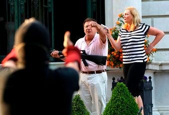 FILE - In this June 28, 2020 file photo, armed homeowners Mark and Patricia McCloskey, standing in front their house confront protesters. (Laurie Skrivan/St. Louis Post-Dispatch via AP File)