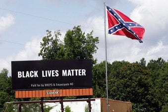 A Black Lives Matter billboard is seen next to a Confederate flag in Pittsboro, N.C., Thursday, July 16, 2020. A group in North Carolina erected the billboard to counter the flag that stands along the road. (AP Photo/Gerry Broome)