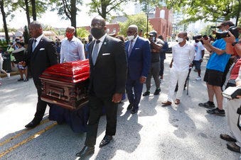 Mourners march with the casket of The Rev. C.T. Vivian to the Martin Luther King, Jr. National Historical Park during a memorial service for the Rev. Vivian, Wednesday, July 22, 2020, in Atlanta. (AP Photo/John Bazemore)