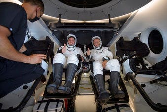 NASA astronauts Robert Behnken, left, and Douglas Hurley are seen inside the SpaceX Crew Dragon Endeavour spacecraft onboard the SpaceX GO Navigator recovery ship. (Bill Ingalls/NASA via AP)