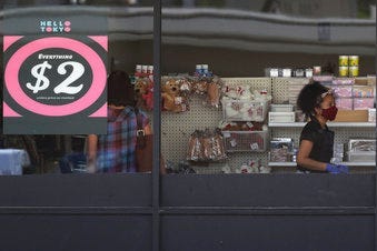 FILE - In this June 25, 2020 file photo, a price sign is displayed at a retail store as a store employee wears a mask while working in Niles, Ill.  (AP Photo/Nam Y. Huh, File)