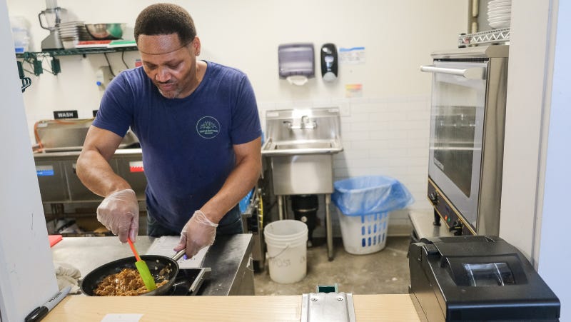 Courtney Boyd, a member of Triple Bottom Brewing’s food prep and snack team, makes a meal in the brewery’s kitchen.