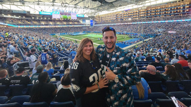 Michael Gordon, in his Eagles suit, and his wife Lauren in an Eagles jersey, amid the crowd at Super Bowl LVII.