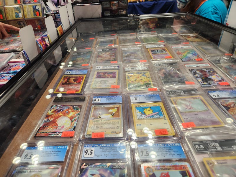 Pokémon cards displayed in a glass case go for hundreds of dollars at The Nerd Out stand at New York City Comic Con 2022.