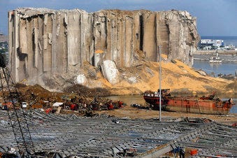 Earth moving equipment and rescue workers search for victims,Monday, Aug. 10, 2020, in Beirut, Lebanon, near the site of last week's explosion that hit the city's seaport. (AP Photo/Bilal Hussein)
