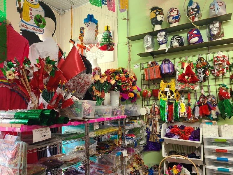 Inside of a business with masks, flowers and other goods.