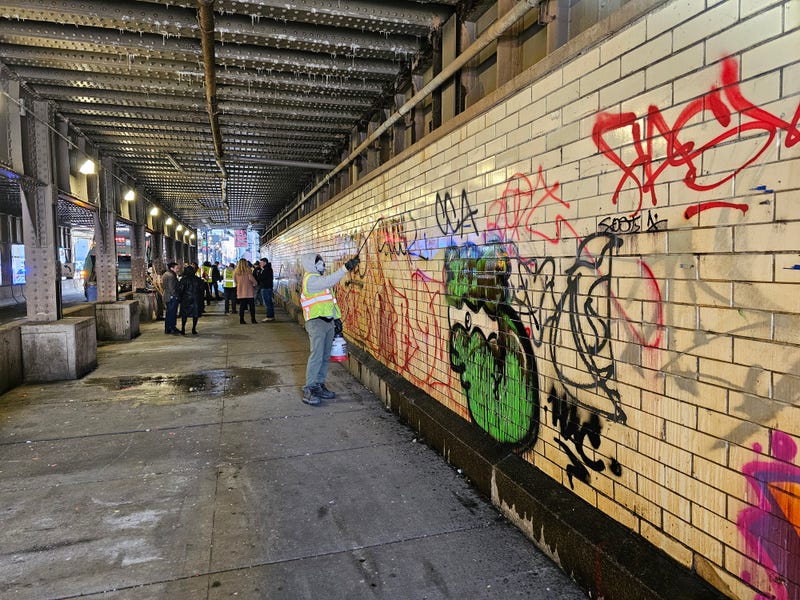 Crews power wash the walls and sidewalks of the viaduct at Clinton and Lake Streets. 