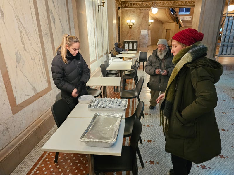 Sophia Senna (L) and Maggie O'Keefe (R) prepare some of the food provided by Chi-Care on Monday at the Chicago Cultural Center.