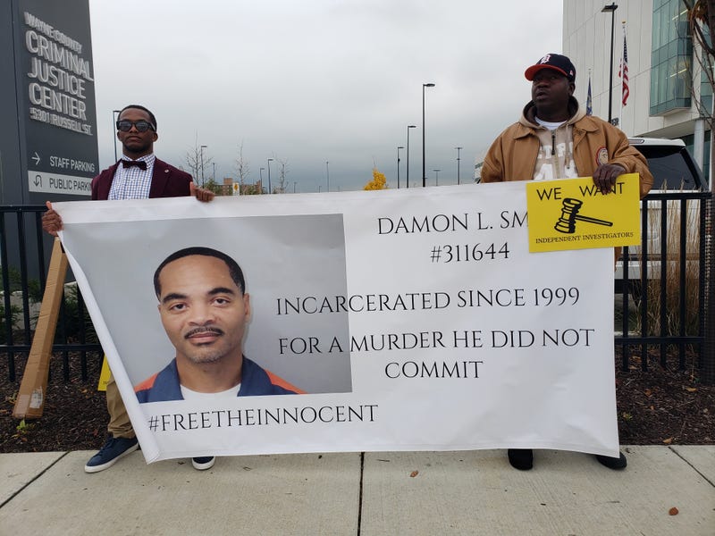 Protesters holding banner with Damon Smith