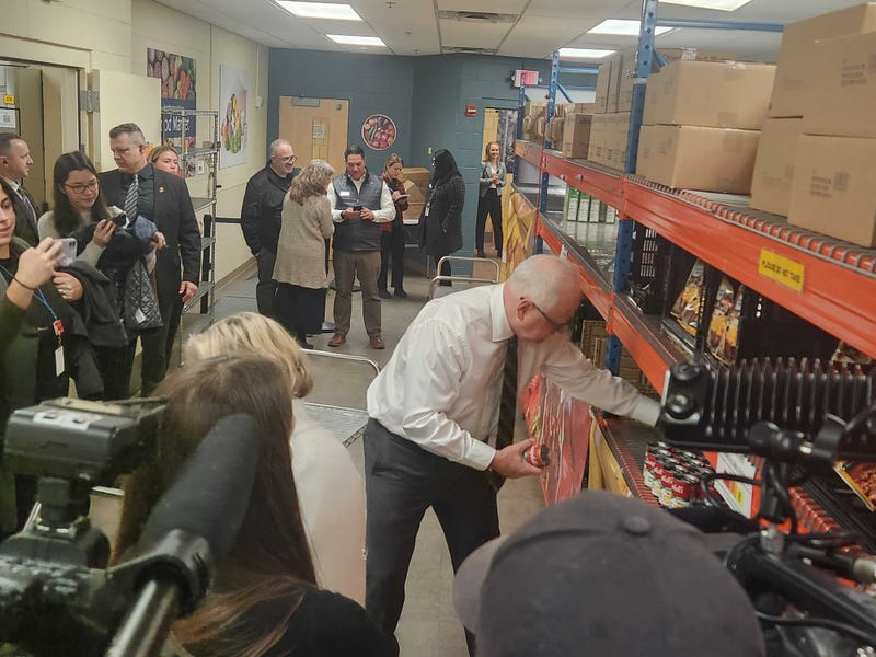 Minnesota Governor Tim Walz volunteering and stacking canned goods at Neighborhood House on St. Paul's west side.
