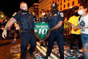 Metropolitan Police carry away a handcuffed protestor along a section of 16th Street, Northwest, renamed Black Lives Matter Plaza, Thursday night , Aug. 27, 2020, in Washington. (AP Photo/Julio Cortez)