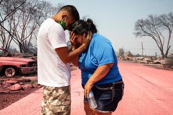 Dora Negrete is consoled consoled by her son Hector Rocha after seeing their destroyed mobile home at the Talent Mobile Estates, Thursday, Sept. 10, 2020, in Talent, Ore., after wildfires devastates the region. (AP Photo/Paula Bronstein)