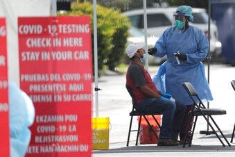 FILE - In this July 6, 2020 file photo, a health care worker administers a COVID-19 test at a site sponsored by Community Heath of South Florida at the Martin Luther King, Jr. Clinica Campesina Health Center in Homestead, Fla.(AP Photo/Lynne Sladky, File)