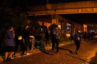 Protesters react to gunfire, Wednesday, Sept. 23, 2020, in Louisville, Ky. (AP Photo/John Minchillo)