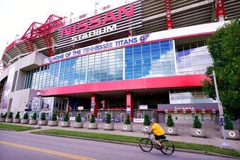 A cyclist passes by Nissan Stadium, home of the Tennessee Titans, Tuesday, Sept. 29, 2020, in Nashville, Tenn. (AP Photo/Mark Humphrey)