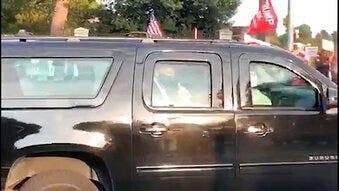 In this image from video, President Donald Trump drives past supporters gathered outside Walter Reed National Military Medical Center in Bethesda, Md., Sunday, Oct. 4, 2020. (AP Photo/Phillip Crowther)