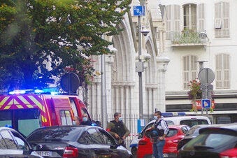 French policemen stand next to Notre Dame church after a knife attack, in Nice, France, Thursday, Oct. 29, 2020. (AP Photo/Alexis Gilli)