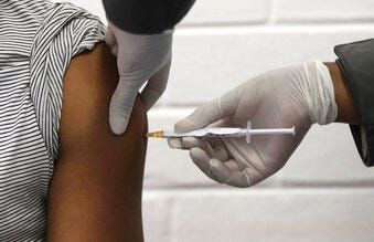 FILE - In this Wednesday, June 24, 2020 file photo, a volunteer receives an injection at the Chris Hani Baragwanath hospital in Soweto, Johannesburg, as part of Africa's first participation in a COVID-19 vaccine trial. (Siphiwe Sibeko/Pool via AP)