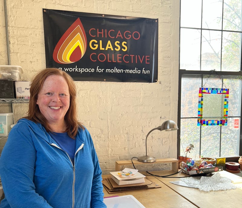 Leslie Speicher stands in front of a sign reading "Chicago Glass Collective"