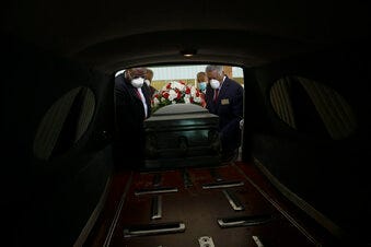FILE - In this Saturday, April 18, 2020 file photo, a casket is placed into a hearse. (AP Photo/Brynn Anderson)